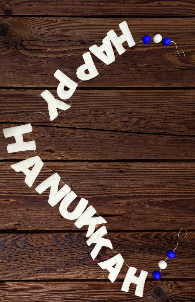 Decorative banner with 'Happy Hanukkah' text in white felt letters