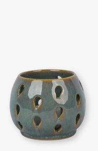 A handmade tea light candle holder with raindrop cut-out design. Made in Nepal.