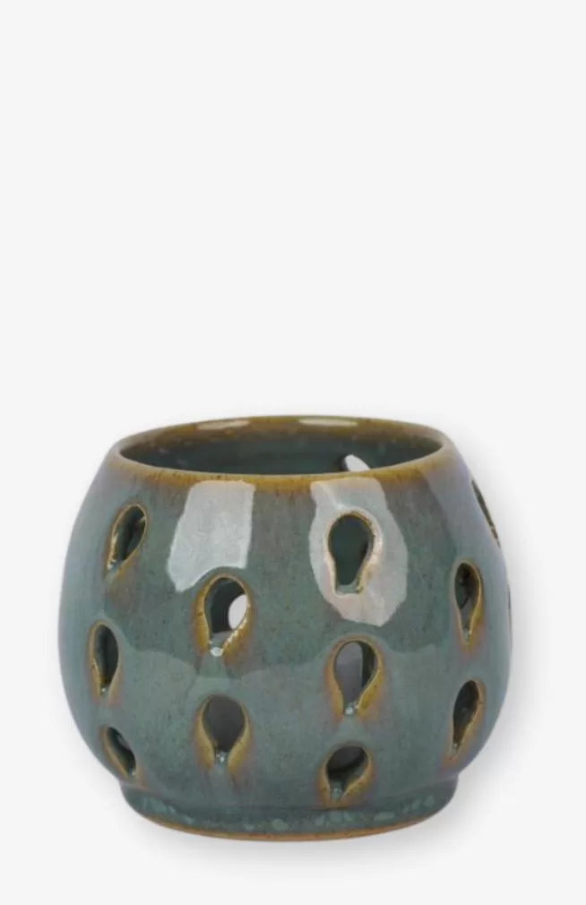 A handmade tea light candle holder with raindrop cut-out design. Made in Nepal.