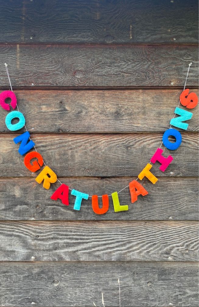 A colorful felt letter garland spelling 'CONGRATULATIONS'. Handmade in Nepal.