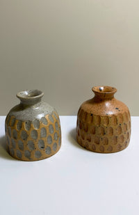 Small handmade ceramic bud vase with textured surface and speckled detail, available in an assortment of colors. Handmade in Nepal.