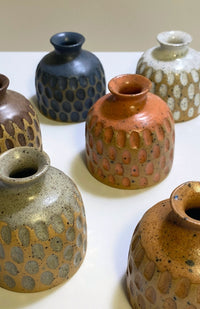 Small handmade ceramic bud vase with textured surface and speckled detail, available in an assortment of colors. Handmade in Nepal.