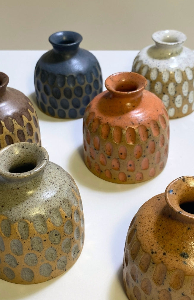 Small handmade ceramic bud vase with textured surface and speckled detail, available in an assortment of colors. Handmade in Nepal.