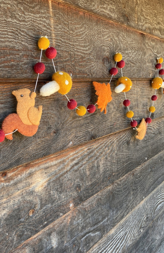 Autumn themed felt garland with yellow mushrooms, brown squirrels, and orange leaves. Handmade in Nepal.