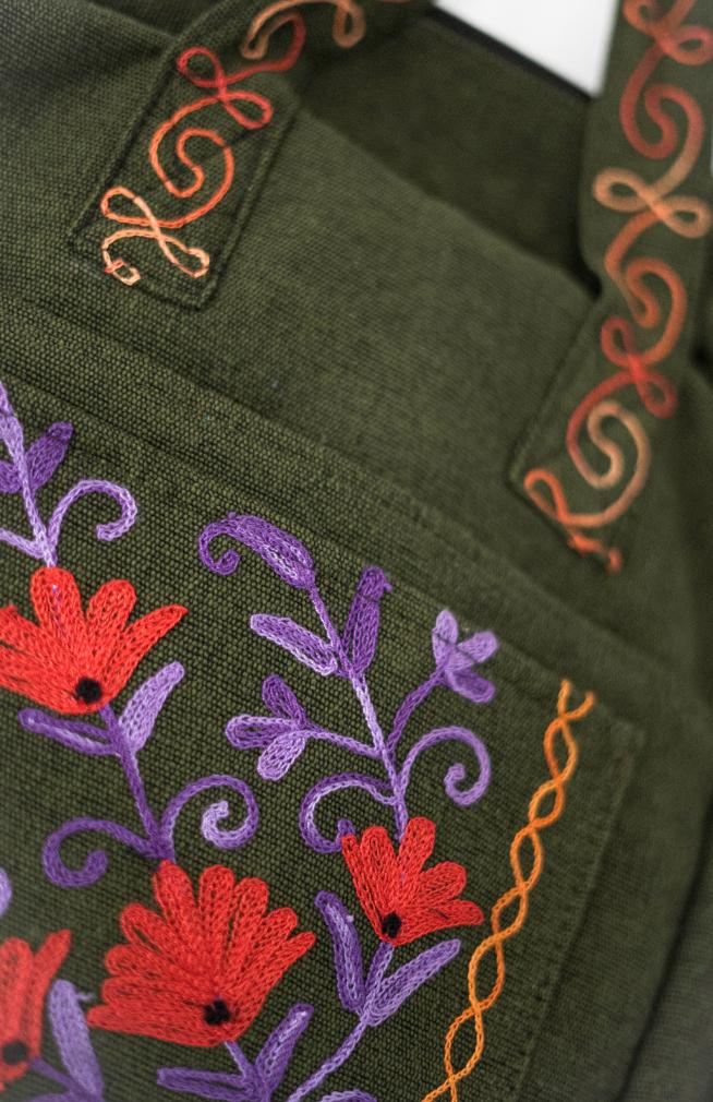 Handmade heavy cotton backpack with floral embroidery and side pockets, made in Nepal.