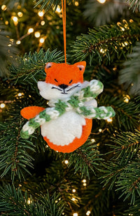 Hand felted orange fox ornament with green and white striped scarf. Handmade in Nepal. Fair trade. 