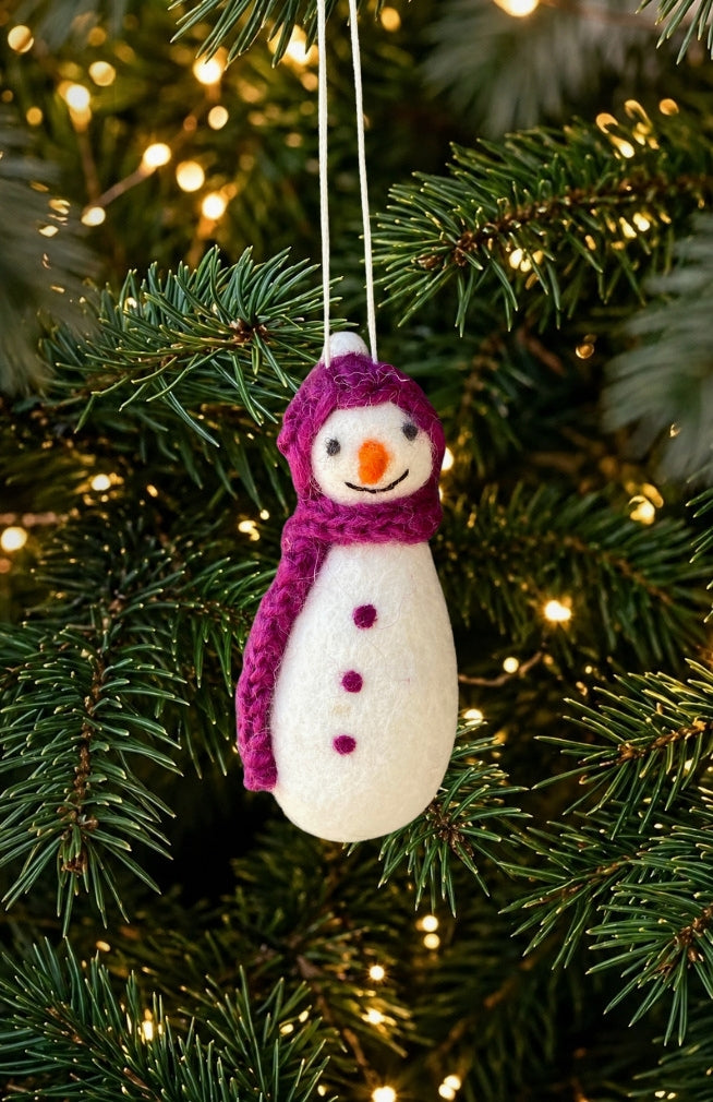 A felt snowman Christmas ornament with a purple hat and scarf, handmade in Nepal.