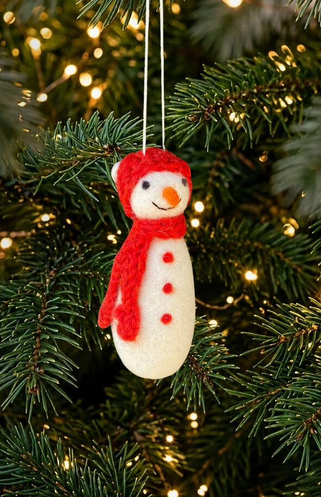 A felt snowman Christmas ornament with a red hat and scarf, handmade in Nepal.
