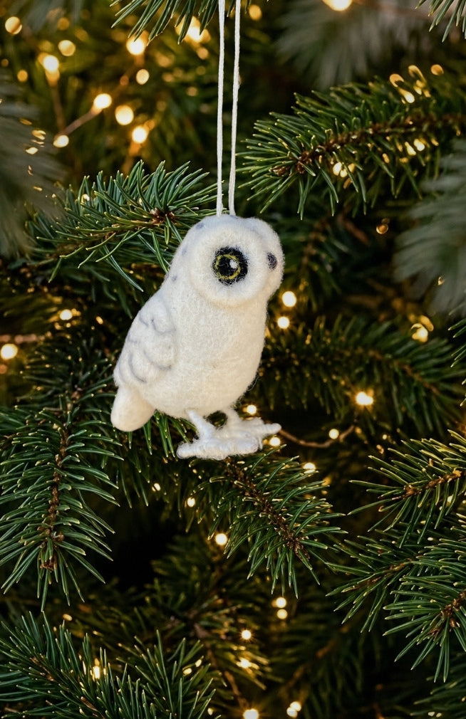 A white snow owl Christmas ornament with bright eyes, handmade with felted wool in Nepal.
