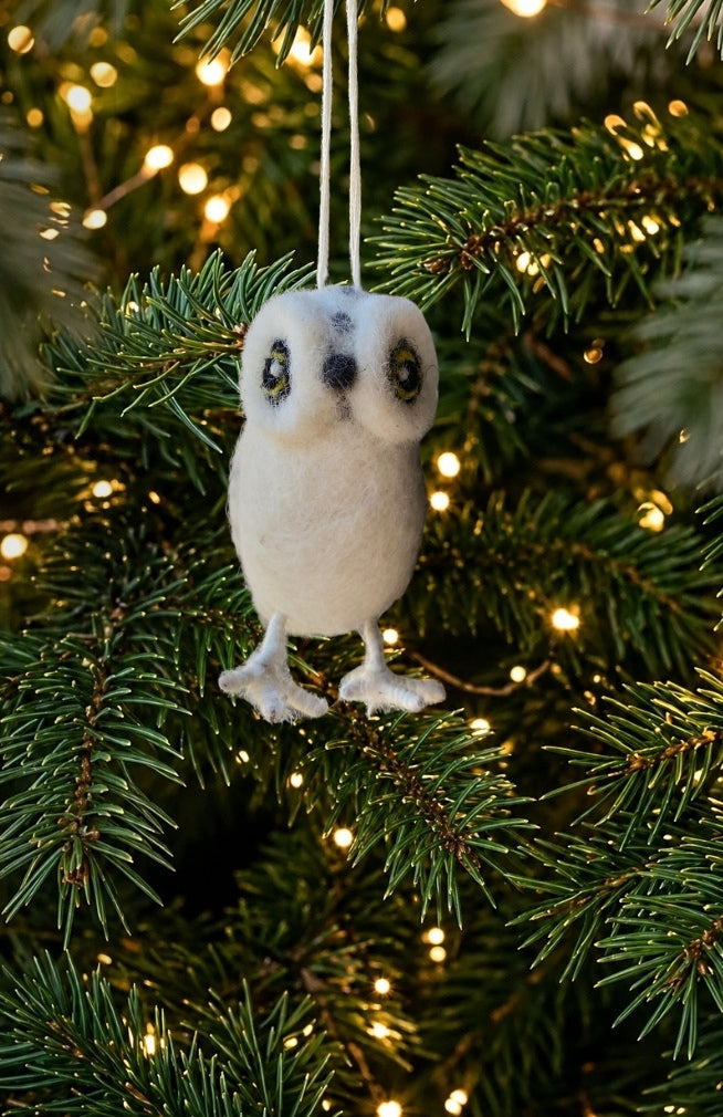 A white snow owl Christmas ornament with bright eyes, handmade with felted wool in Nepal.