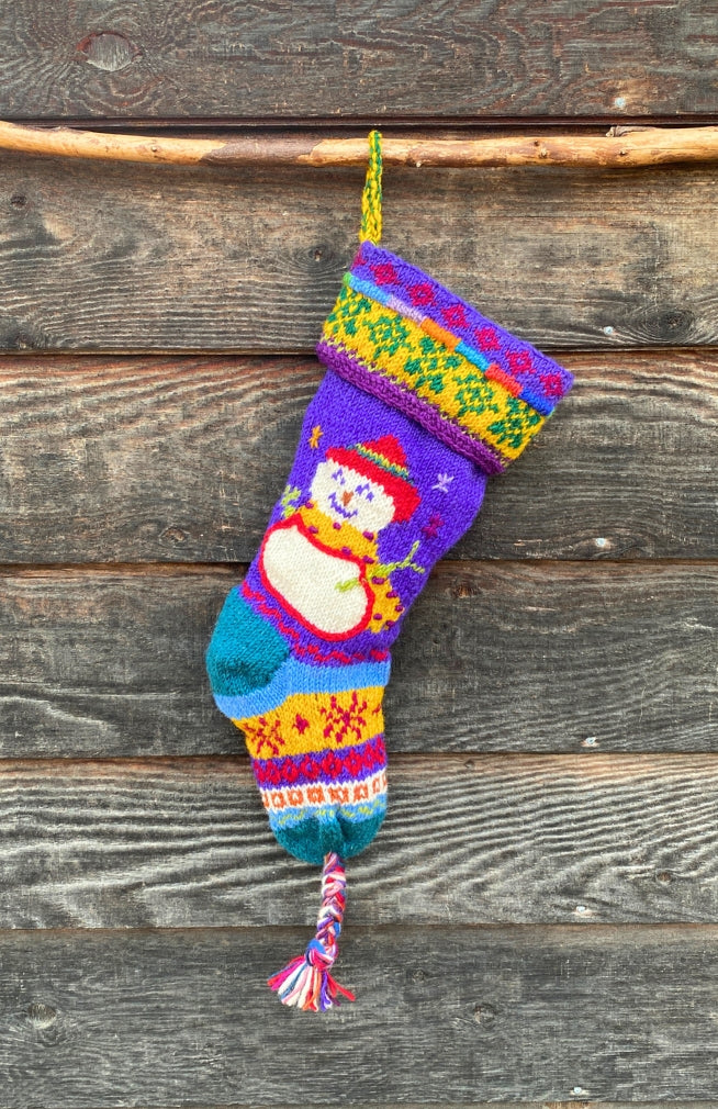 A colorful hand-knit Christmas stocking with a snowman design, handcrafted by artisans in Nepal. Beautiful design, fair trade, unique holiday decor!