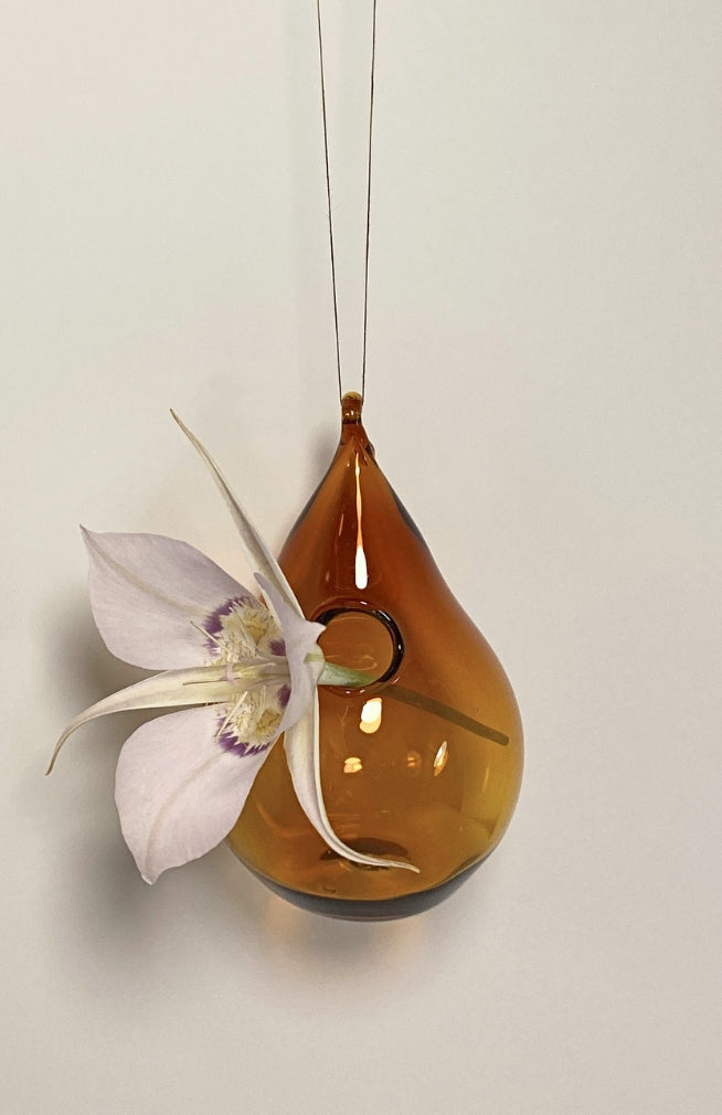 A handblown glass hanging bud vase in tear drop shape with loop for hanging. Fair trade and handmade in Nepal. 