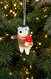 A felt hedgehog ornament wearing a brown sweater and holding a red mushroom, Handmade in Nepal.