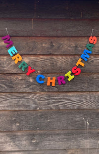 A colorful 'MERRY CHRISTMAS' letter garland made of felt, handmade in Nepal.