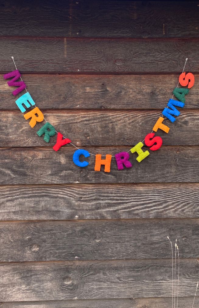A colorful 'MERRY CHRISTMAS' letter garland made of felt, handmade in Nepal.
