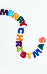 A colorful 'MERRY CHRISTMAS' letter garland made of felt, handmade in Nepal.