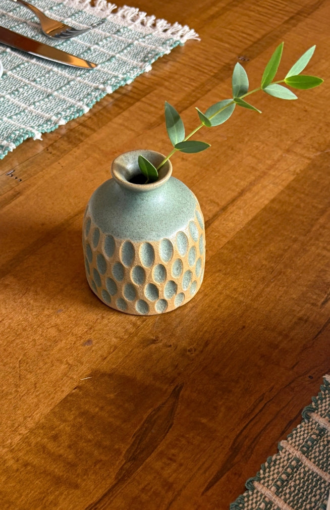 A small round ceramic bud vase with a textured surface and speckled brown and tan glaze, handmade in Nepal.