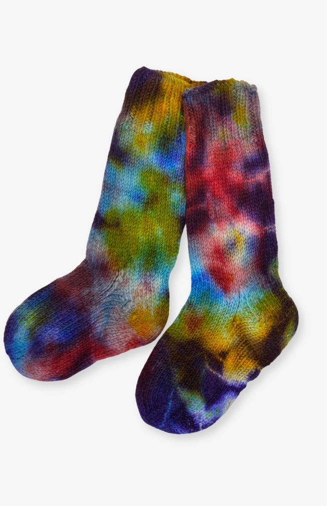 A pair of hand-knit socks featuring a vibrant tie-dye pattern with blue, purple, green, yellow, and red tones. Handmade by artisans in Nepal.