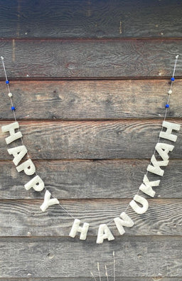 Felt "HAPPY HANUKKAH" banner with white letters and three felted balls in blue, white, blue, at each end