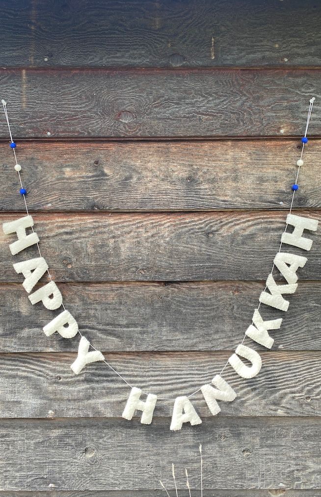 Felt "HAPPY HANUKKAH" banner with white letters and three felted balls in blue, white, blue, at each end