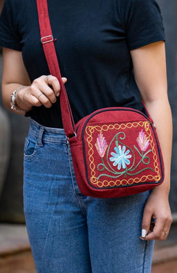 Hand embroidered cotton purse with rounded zippered top and adjustable strap