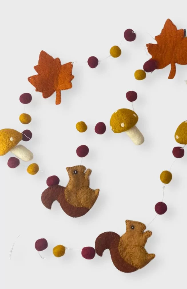 Autumn themed felt garland with yellow mushrooms, brown squirrels, and orange leaves. Handmade in Nepal.