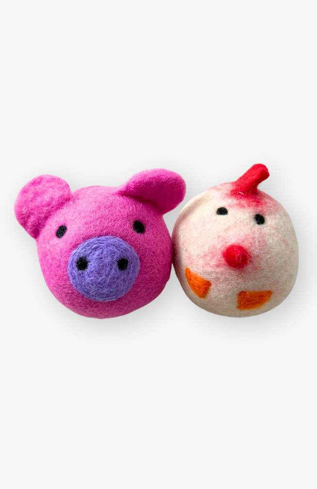 two felted wool dryer balls, one chicken and one pink pig with curly tail