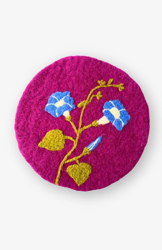 Hand felted morning glory flower trivet on purple background